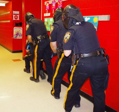 Four Vernon police officers are shown about to enter a classroom in search of three gunmen.