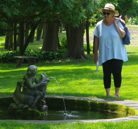 A visitor is shown admiring one of the numerous fountains at Meadowburn Farm.