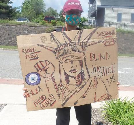 Mary Elaine holding her sign: Statue of Liberty, George Floyd, Breonna Taylor, Ahmad Aubrey #BLM