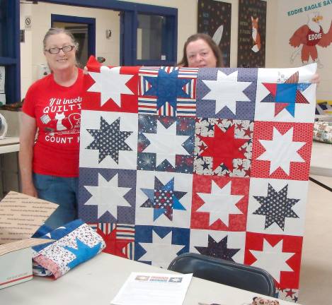 The ladies show off this amazing quilt