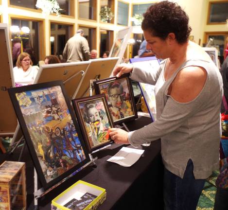 Marcia Letizia adjusts her artwork displayed in the Highland Lakes Country Club&#xfe;&#xc4;&#xf4;s Lake Room by the Highland Lakes Artists Group.