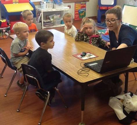 Preschoolers are shown learning about computers.