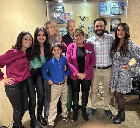 Puzzle solver takes turn at wheel Carla Householder, center, and her family pose with cutouts of Pat Sajak and Vanna White at ABC Studios in California, where ‘Wheel of Fortune’ is taped. From left are her daughters Marissa DeVita and Mariel Cattani, grandson Anthony DeVita, son Joseph Householder and Emma Kramer, fiancée of her other son. (Photo provided)