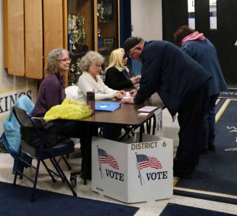Poll workers check in citizens to vote at the Vernon Township High School.