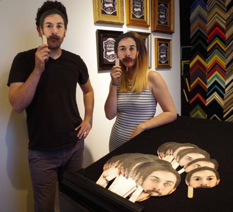 Hamburg&#xfe;&#xc4;&#xf4;s Art Etc Gallery owner Marshall Okin and staffer Angelica Lombardi done masks that feature the face of &#xfe;&#xc4;&#xfa;Supergood&#xfe;&#xc4;&#xf9; artist Garret Torres.