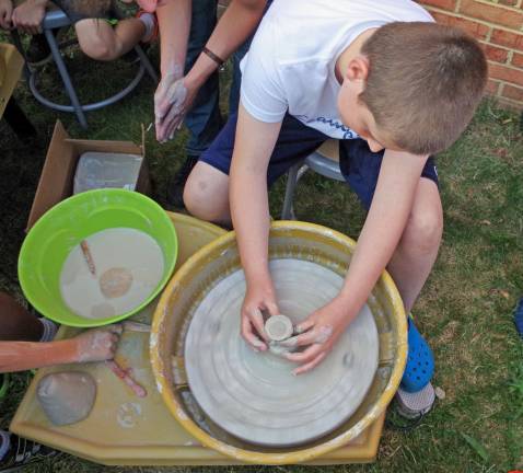 Zachary Betancourt, 12, tried out the one of two potter&#xfe;&#xc4;&#xf4;s wheels that were available under the watchful eyes of Vernon Township High School art teacher Lisa Hirkaler and student Justin Schneider.