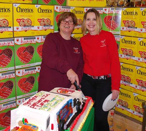 ShopRite workers honored as hunger-fighting heroes Tammy and Daniela cut the Partners in Caring themed cake for the event to share with the team and customers.