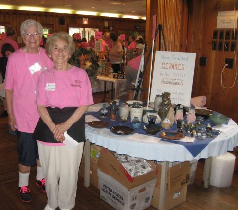 Volunteers Terri Van Emburgh and Mary Ann Mastrangelo work a table of hand thrown pottery created by Aaron Garvin. Garvin is 94 years old and donates all his creations to the yard sale.
