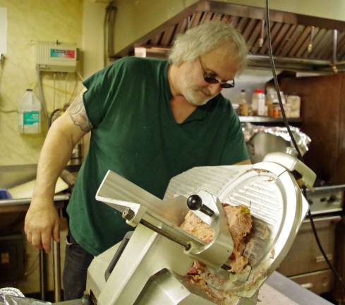 New bar manager Dave Schnell slices up another plate of corned beef. By 5 p.m., about 80 meals were prepared for patrons.