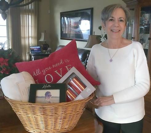 The GFWC Vernon Township Woman’s Club donated a “romance basket” to Family Promise for the agency’s Great Gatsby fundraiser in January. The love themed basket - containing a throw pillow, soft blanket, candles and picture frame - was auctioned off during the tricky tray portion of the event. Arleen Hill, one of the newest members of the Woman’s Club, displays the beautiful basket she volunteered to assemble.