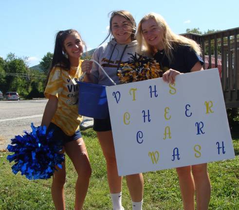 Members of the Vernon Township High School Varsity Cheerleaders (from left) Julia Hagedoorn, Theresa Auletta and Faith Waller encourage Saturday drivers to have their cars washed at a benefit car wash held at the McAfee Firehouse