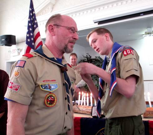 New Eagle scout Steven Schneider awards eight-year previous Scoutmaster of Troop 404 Bo Housde with a mentor pin.