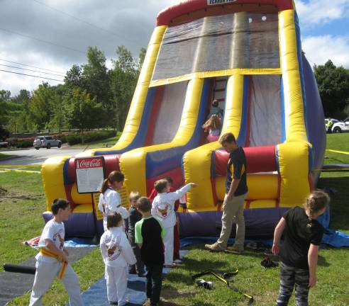 Street fair showcases Vernon businesses PAL volunteers man the busy bounce house.