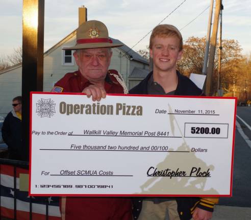Teary-eyed VFW Post Commander Jim Davis stands beside Christopher Ploch as he holds Ploch&#xfe;&#xc4;&#xf4;s symbolic check for $5,200. The check represents the proceeds of Ploch&#xfe;&#xc4;&#xf4;s successful &#xfe;&#xc4;&#xfa;Operation Pizza&#xfe;&#xc4;&#xf9; fundraising drive.
