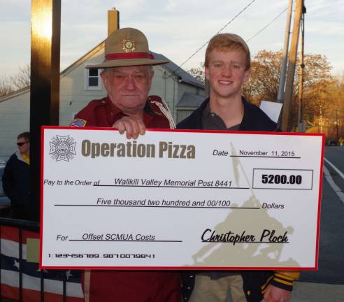‘Operation Pizza’ comes to fruition Teary-eyed VFW Post Commander Jim Davis stands beside Christopher Ploch as he holds PlochþÄôs symbolic check for $5,200. The check represents the proceeds of PlochþÄôs successful þÄúOperation PizzaþÄù fundraising drive.