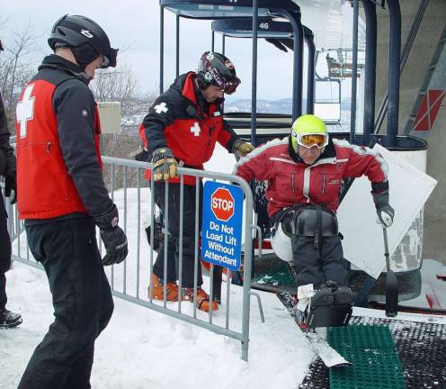 Adaptive ski committee tests Mountain Creek lifts The PSIA adaptive instructor demonstrates how to exit the Cabriolet lift observed by Susanne Ebling and other ski patrollers.