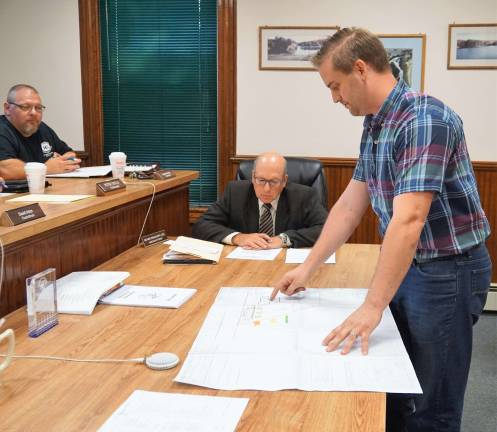 Standing on right, Holden Schwabe, of Schwabe Contracting, presents the request to pave the adjacent lot to Sam's Convenience Store.