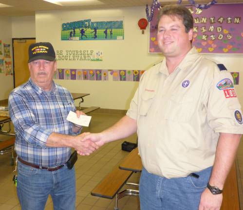 Cubmaster of Pack 183, Craig McCarrick presents a check to VFW Post #8441 member Tom Gundlach.