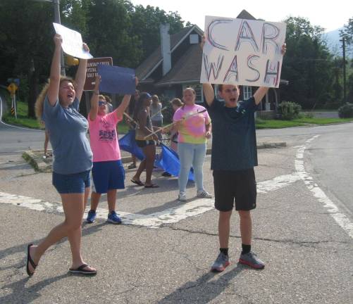 PHOTOS BY JANET REDYKEMembers of the Vernon Township High School Band attract cars for a summer car wash at the McAfee Fire Department.