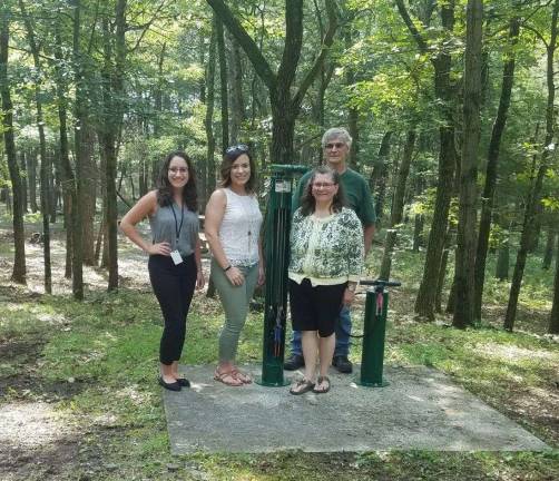 Jessica Ridgeway, planner (left), and Lauren Buda, public health educator (left, center), coordinators of the Orange County Creating Healthy Schools and Communities Grant, stand with Beverly Arlequeeuw (right, center), director of the Port Jervis Free Library, and Mike Ward (right), president of the Port Jervis Outdoor Club at the installed bicycle repair station near Elks Brox park camping area. (Photo provided)