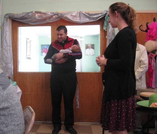 Church pastor Father Ricardo offers a prayer and blessing while holding a first time tea party goer.