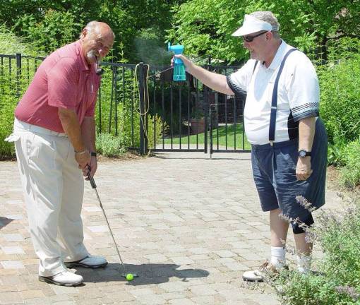 Putting Contest winner Al Izzi is cooled off by fellow golfer Dave Bruinooge after sinking his winning putt.
