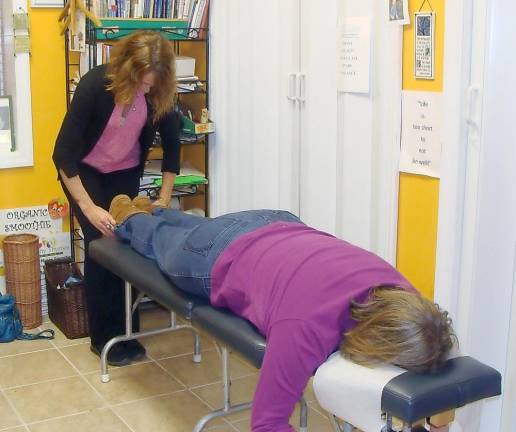 Chiropractor Dr. Studer checks the alignment of Healthy Thymes visitor Caitlin Neill of Highland Lakes.