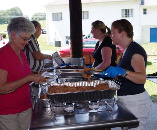 Lorraine Hentz, director of the Sussex County Division of Senior Services, serves some pulled pork made by Eric Figueroa&#xfe;&#xc4;&#xf4;s Double S Diner in Wantage.