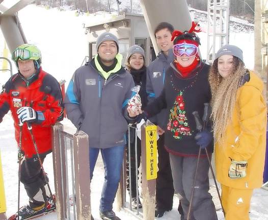 Buffy (2nd from right) gives Christmas cookies to the Sugar Slope lift operators from Brazil, Peru and Vernon Township along with one of their Ski Patrol buddies