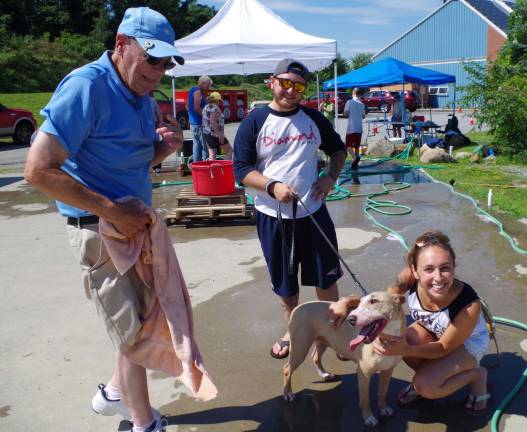 At the left, volunteer Chuck Thompson just finished the dry cycle for Heidi, a bull terrier/amstaff mix and her human companions Chris DeMarco and Ariana Wenger. All four are Vernon residents.