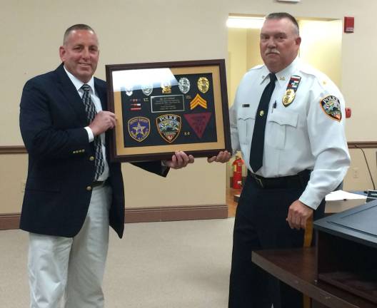 Vernon Police Chief Randy Mills presents retired Sgt. William Gebhard with a plaque commemorating his service.