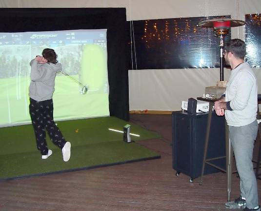 Hef’s Hut opens with golf simulator, pool table, and heated patio — and attracts locals Mark Creamer, marketing and sales manager at Great Gorge Golf Club, watches a guest hit a tee shot in the long drive competition (Photo by Dr. John T. Whiting)