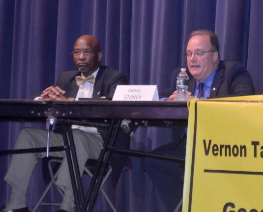 Mayoral candidate Daniel Storey, right, speaks while fellow candidate Howard Burrell listens during Wednesday's candidate forum at Vernon Township High School.