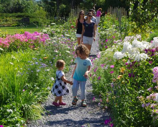 Sisters Olivia Loberg, 4 and Everly, 1, of Warwick, N.Y., lead their mother Sasha and other family members through the gardens.
