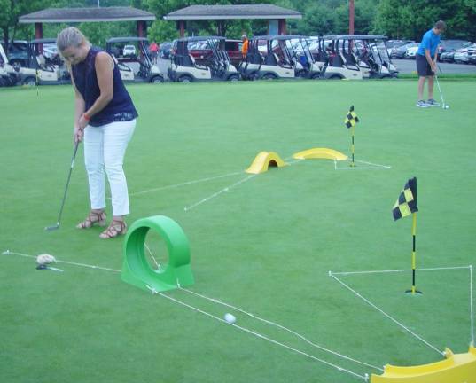 A Mom gives the Golf Putting Contest her best effort.