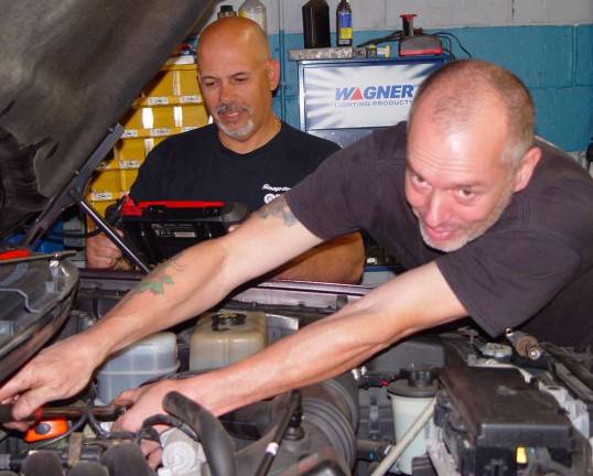 Joe Lisa of Vernon and owner of A-Tec Tire &amp; Auto Center and Mike Williams work on a customer&#x2019;s car