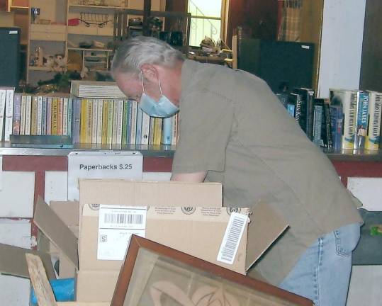 Lusscroft Farm volunteer Don Traylor organizes the multitude of donations for Saturday's barn sale.