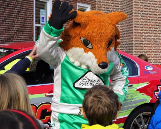 Foxy waves while students inspect the Pocono Raceway Pace Car.