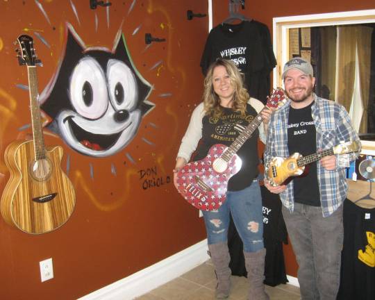 PHOTOS BY JANET REDYKE Tina Bradshaw and Andrew Gallagher pose in their new music shop The Rusty Hill with guitars designed by Don Oriolo.