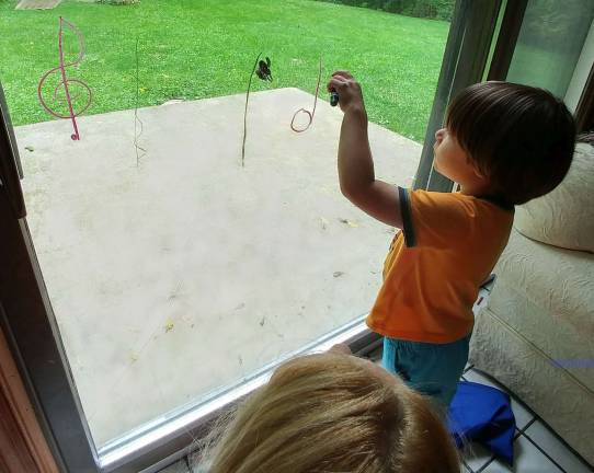 Solomon Honeywell, 4, of Vernon practices writing quarter notes and half notes on my sliding glass doors, to reinforce his learning to differentiate between the two kinds of notes.
