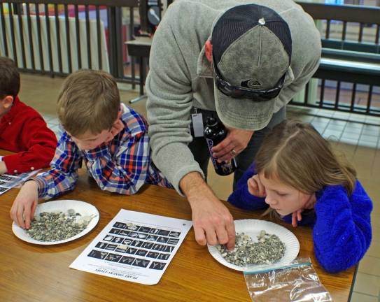 Vernon resident Dru Brooks helps his children Finn, 7, and Bella, 9, sift through their plates of multi-million-year-old fossil-laden debris.