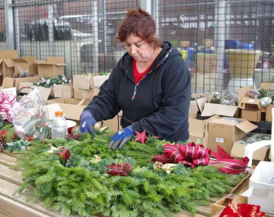 Delia Gutirrez is shown creating a Christmas wreath at Heaven Hill Farm.