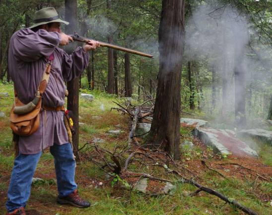Henry DiGuilio of the Highland Lakes section of Vernon is shown firing his musket on Saturday afternoon in the woods at High Breeze Farm. Sparks can be seen in the air below the musket&#xfe;&#xc4;&#xf4;s muzzle.