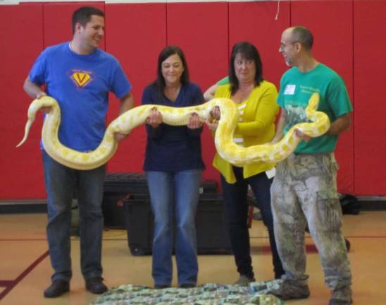 Mike Wilson, Cindy Monico, Janice Wallace and Dominic Rizzo are shown with a 12-foot python.