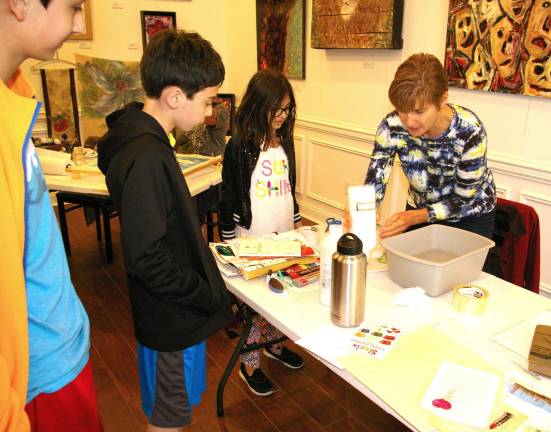Claude Larson of Frankford shows the next generation of artists how to transfer printed images onto their own artistic creations.