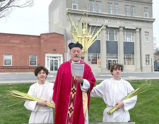 Father Robert Griner delivers the Liturgy of the Palms on the Newton Green with his sons Jesse and Elliott serving as acolytes.