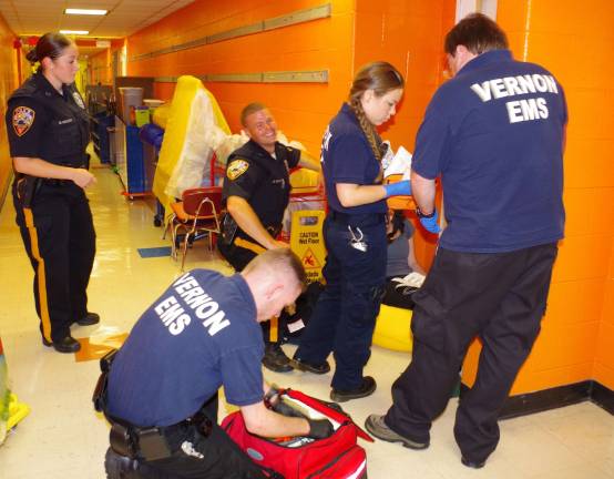 Police and EMS personnel are shown helping a &quot;wounded&quot; student.