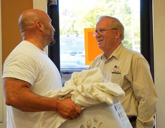 Gary Gardner, on right, greets customer Tony Germano, on left.