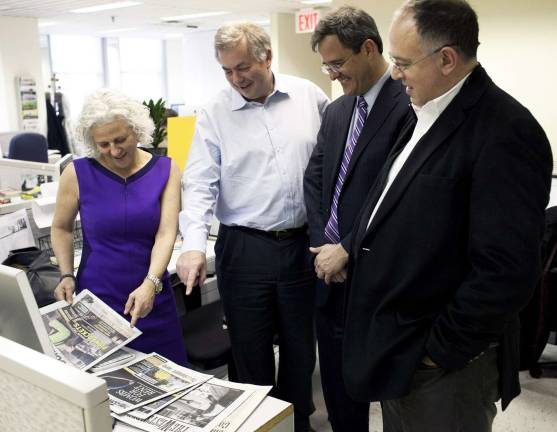 Straus News enters the Manhattan neighborhood news market Photo by Aaron Adler/Manhattan Media Jeanne Straus, president of Straus News, looks over issues of her company's newly acquired New York City weeklies with William Pecover, Tom Allon and Richard Burns of Manhattan Media.