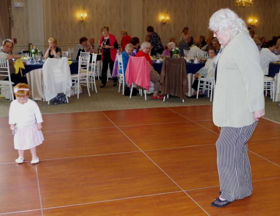 Outstanding Senior of the Year Charles McSpiritt's granddaughter, Allison, 2, dances with Vernon senior Bunny Music.